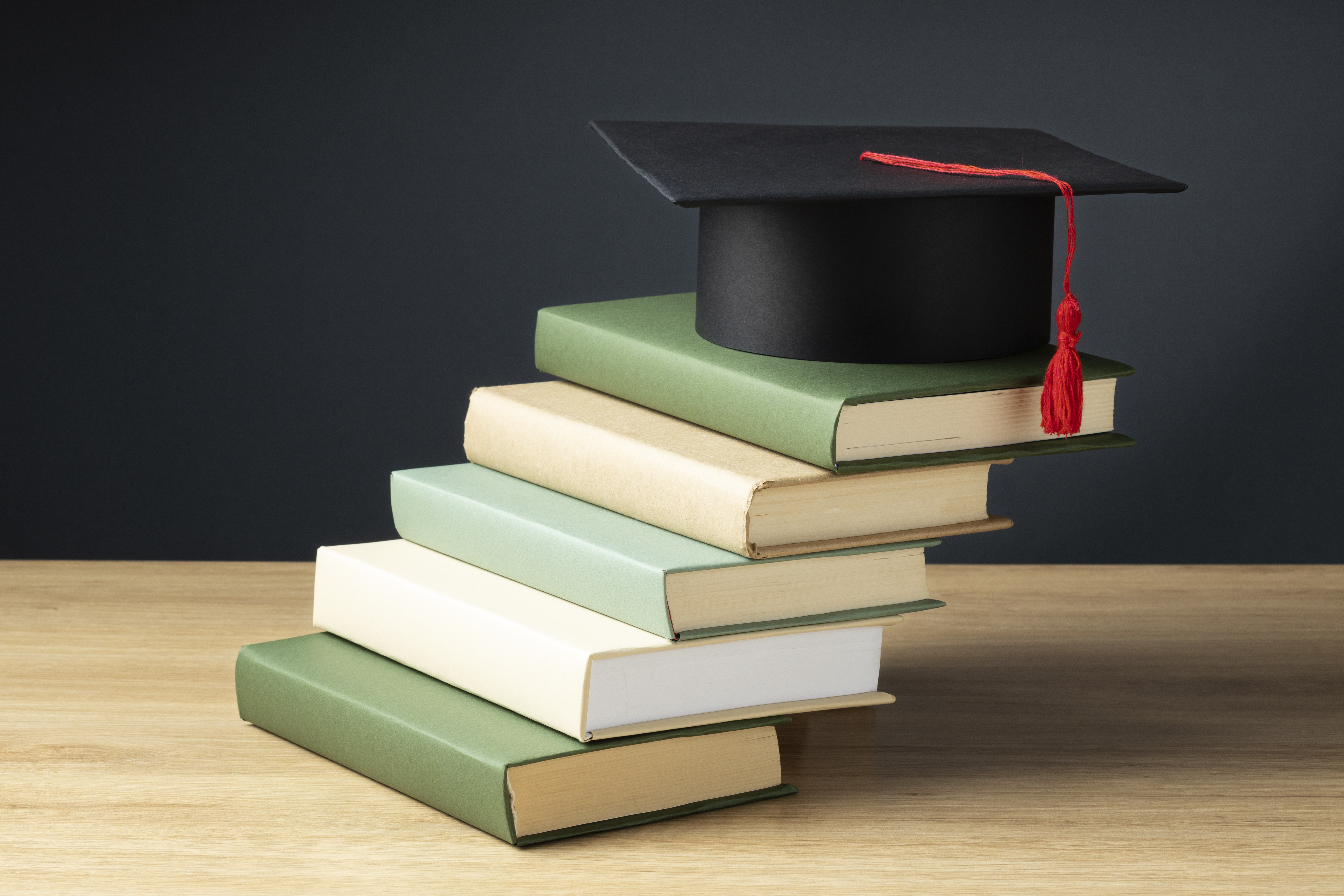 high-angle-books-graduation-cap-education-day.jpg